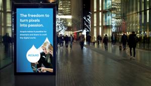 Color photograph of urban street scene at night with a digital ad display in the foreground