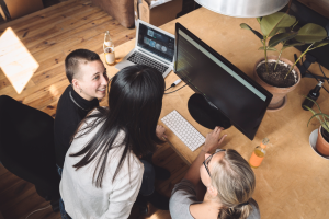 overhead photo of three people at a desk