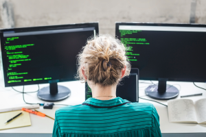 Man on a computer with two screens