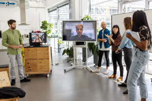 Group of people standing are screens with faces