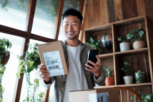 Man holding package and mobile phone