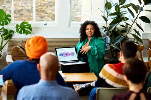 Color photo of woman giving a presentation from her laptop