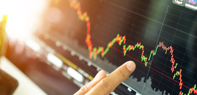 Finger pointing to screen showing stock market trends