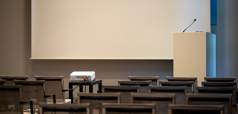 Empty lecture hall with podium and projector screen