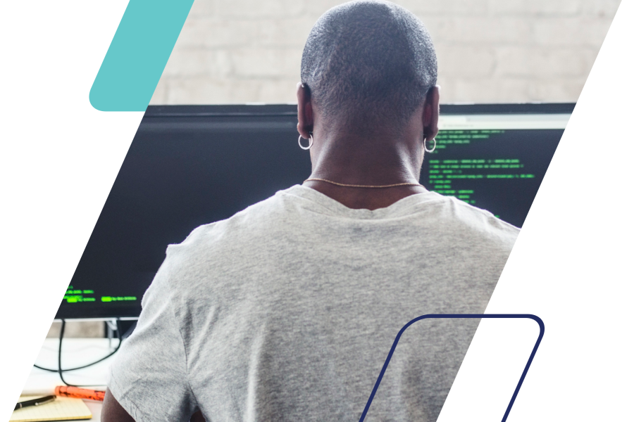 Image of a person coding on dual monitors masked by a parallelogram