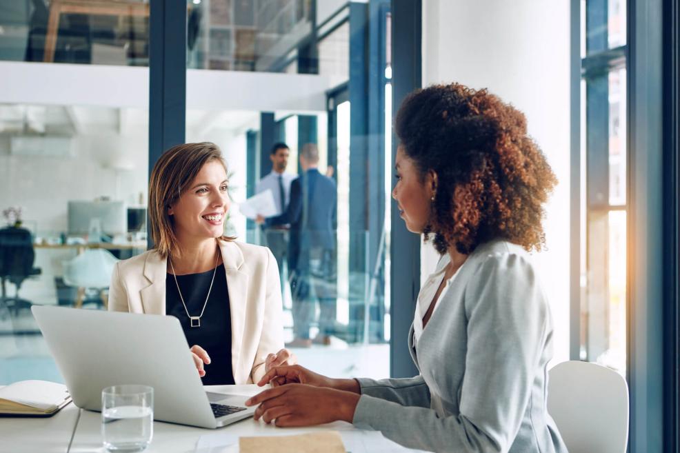 Two women talking over laptop
