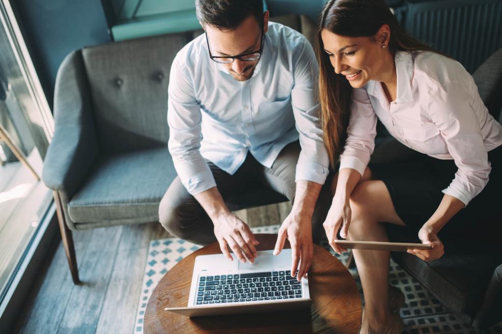 Man and woman on couch looking at laptop