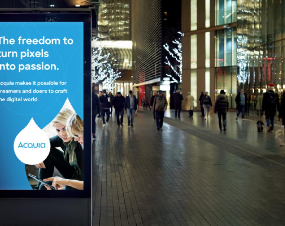 Color photograph of urban street scene at night with a digital ad display in the foreground