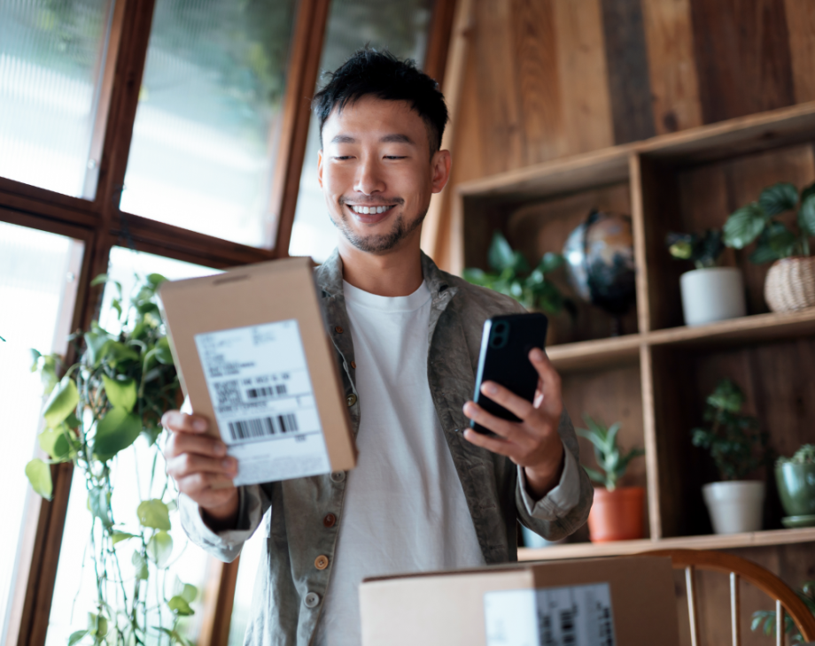Man holding package and mobile phone